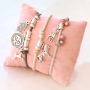 Bracelets &eacute;lastiques et colliers superpos&eacute;s avec des breloques en m&eacute;tal 
