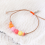 Un joyeux ensemble de bijoux avec des perles alphabet, des breloques fimo, des perles en bois et des perles Katsuki